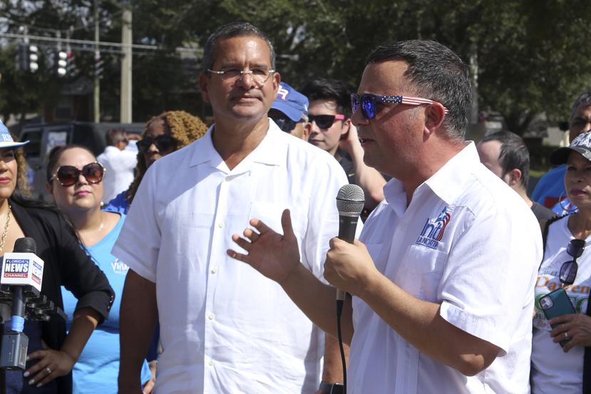 El gobernador Pedro Pierluisi escucha mientras el congresista puertorriqueño Darren Soto habla ante el público que asistió a una caravana en Kissimmee.