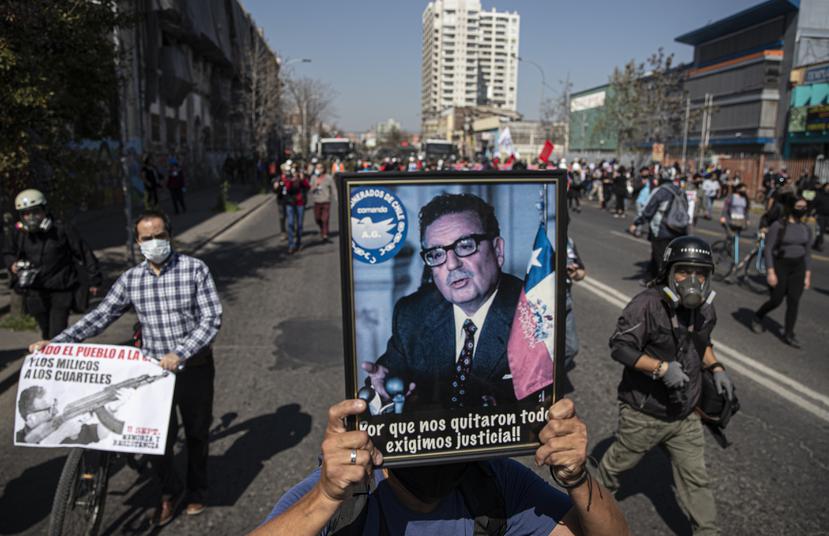 Un manifestante carga un cuadro con la foto del expresidente chileno Salvador Allende durante las protestas de la conmemoración por las víctimas del golpe de estado.
