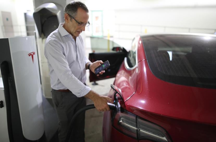 El ingeniero Adolfo L. González, presidente de Empresas Caparra, hace uso del primer supercargador de autos Tesla que hay en Puerto Rico y que forma parte del ofrecimiento del centro comercial.