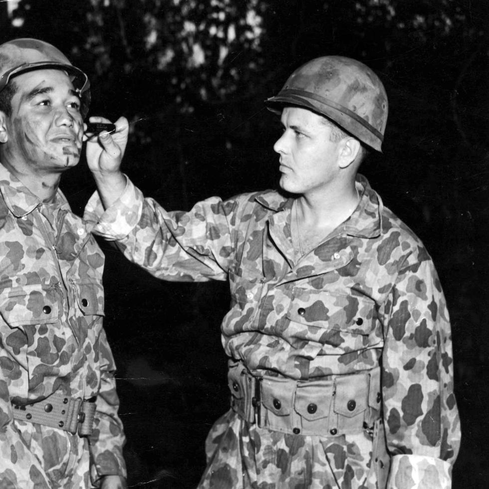 El soldado Raymond Walozak (dcha) le pinta el rostro a Sixto Escobar, entonces soldado del Ejército de EE.UU., durante entrenamientos en la zona del Canal de Panamá en 1944. (Archivo)