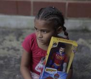 Una niña con su muñeco de Super Bigote en el vecindario Carayaca de La Guaira, Venezuela.