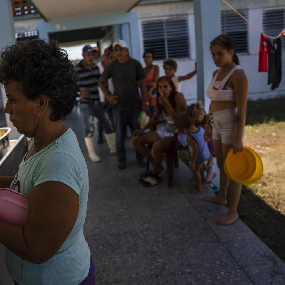 Cubanos buscan una comida caliente en una escuela que sirve como refugio en La Coloma.
