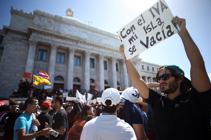 Un joven se manifiesta con un cartel frente al Capitolio en el lado sur.