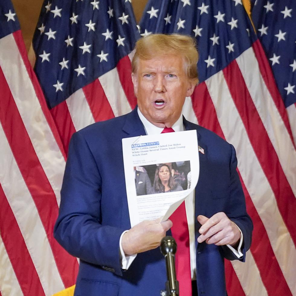 El expresidente Donald Trump sostiene una copia de un reportaje en el que aparece la fiscal general de Nueva York, Letitia James, mientras habla durante una rueda de prensa, el jueves 11 de enero de 2024, en Nueva York.