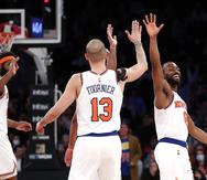Kemba Walker (derecha), de los Knicks de Nueva York, festeja con Evan Fournier, luego de atinar un triple ante los Pistons de Detroit.