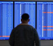 Un pasajero ve la pantalla del estatus de los vuelos en el aeropuerto Ronald Reagan, en Arlington.