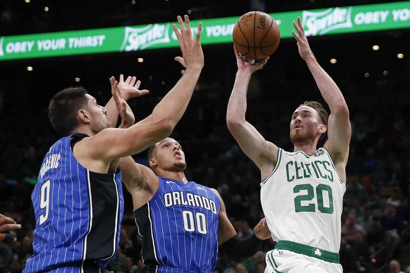 Gordon Hayward de los Celtics de Boston, intenta un tiro ante la defensa de Nikola Vucevic y Aaron Gordon.  (AP)