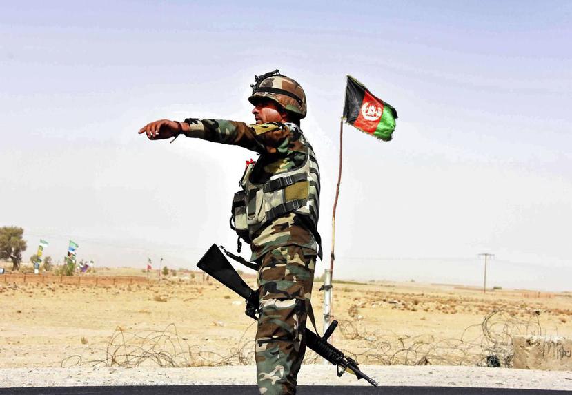 Un militar afgano da instrucciones a un vehículo para que se detenga en un puesto de control en Zhari, Afganistán (AP).