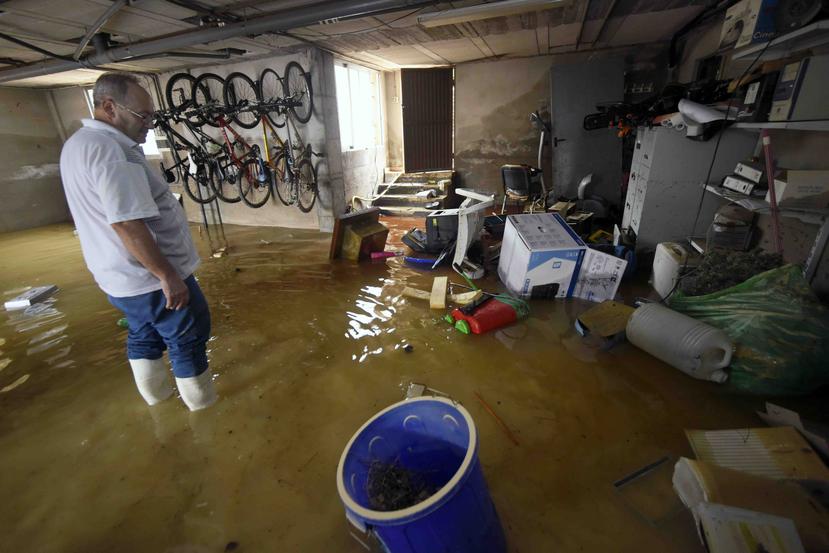 Un hombre camina por el garaje de su casa que se vio afectada por inundaciones. (AP / Alfonso Durán)
