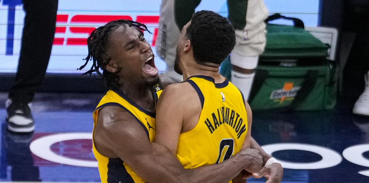 El armador de los Pacers de Indiana Tyrese Haliburton (0) es abrazado por su compañero el alero Aaron Nesmith (23) luego de atinar el tiro ganador durante la prórroga en el 2do juego de la ronda de la primera ronda playoffs de la NBA, el viernes 26 de abril de 2024, en Indianápolis.