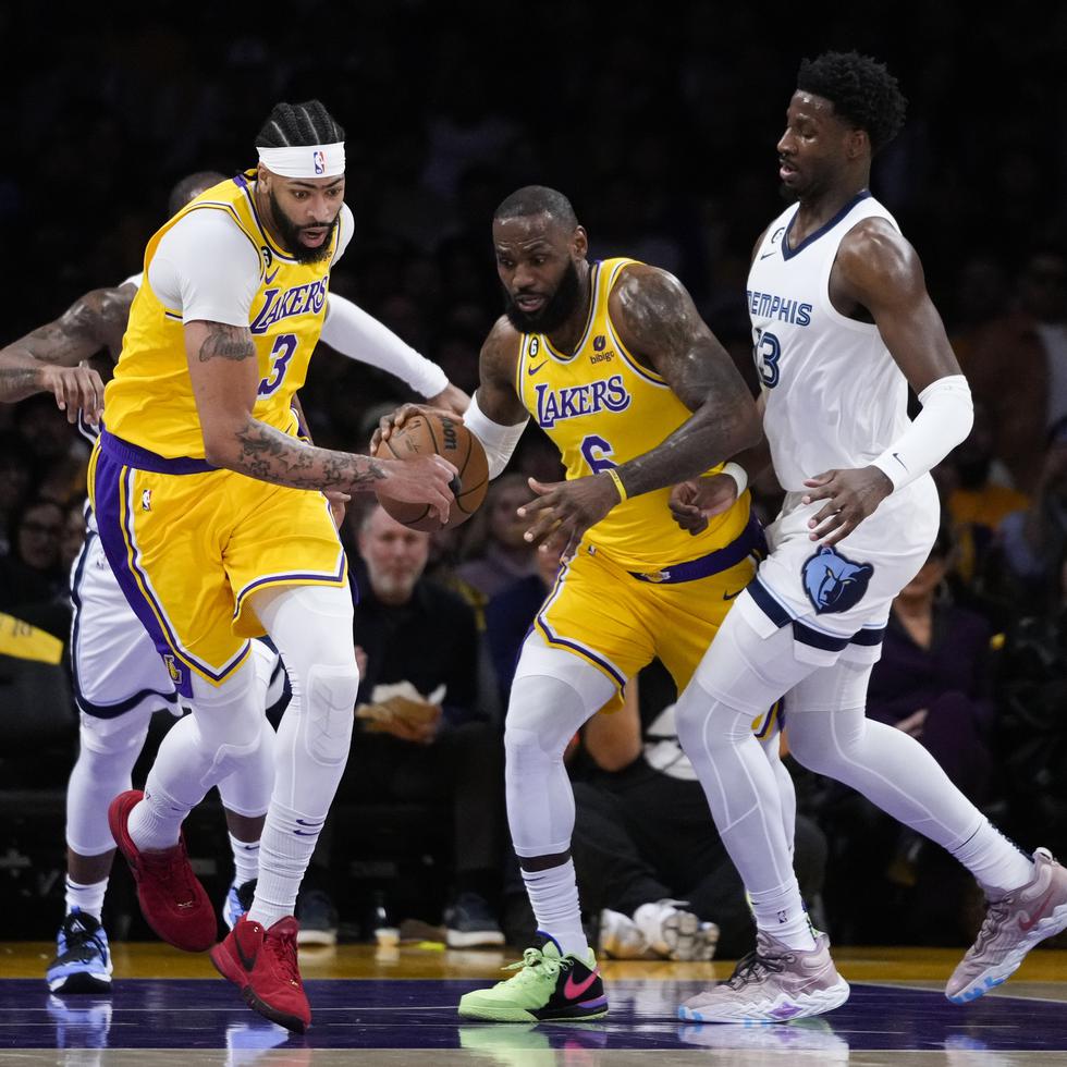 LeBron James (6) de Los Angeles Lakers regatea bajo la presión de Jaren Jackson Jr. de Memphis Grizzlies, a la derecha, mientras Anthony Davis (3) de los Lakers avanza por la cancha durante la primera mitad del Juego 4 de los playoffs en Los Ángeles.
