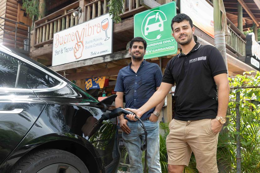 Los hermanos Leonardo y Jumil Cabán cargan un automóvil eléctrico en la estación a las afueras del restaurante Buena Vibra, en Cabo Rojo.