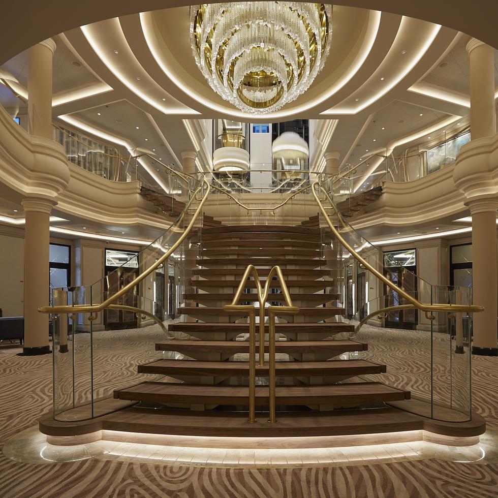 La escalera del atrio central del Seven Seas Splendor sirve de preámbulo para una travesía única en su clase.