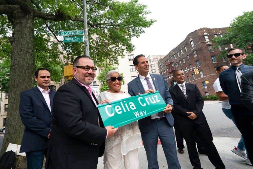 Omer Pardillo, exmanager de Celia Cruz, a la izquierda, Ruth Sánchez Laviera, quien fue amiga de la difunta cantante cubana, y el concejal de Nueva York Fernando Cabrera, a la derecha, sostienen un letrero con las palabras Celia Cruz Way.