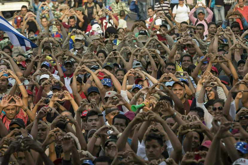 Partidarios del gobierno venezolano hacen el signo de corazón con las manos durante el concierto "Manos Fuera de Venezuela" junto al Puente Internacional Tienditas, en la frontera con Colombia, el viernes, 22 de febrero del 2019.  (AP/Rodrigo Abd)