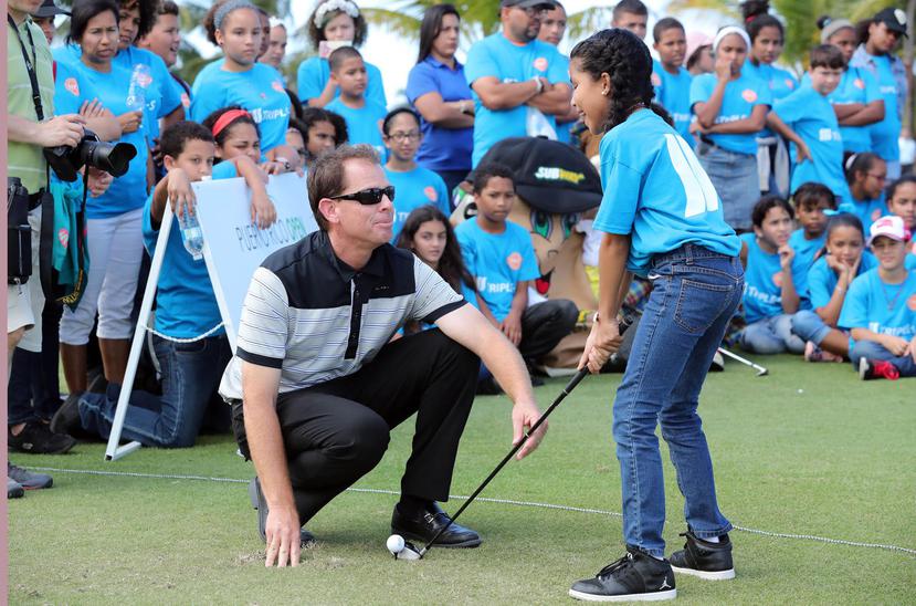 Alberto Ríos, profesional del Bahía Beach Golf Club, le enseña a Miangelys Pagán, de la escuela  elemental Rafael Rexach Dueño de Río Grande, la forma correcta de agarrar un palo de golf y pegarle a la pelota.