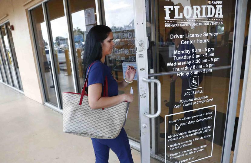 Una mujer ingresa al departamento de transportes de la Florida en Hialeah. (AP)