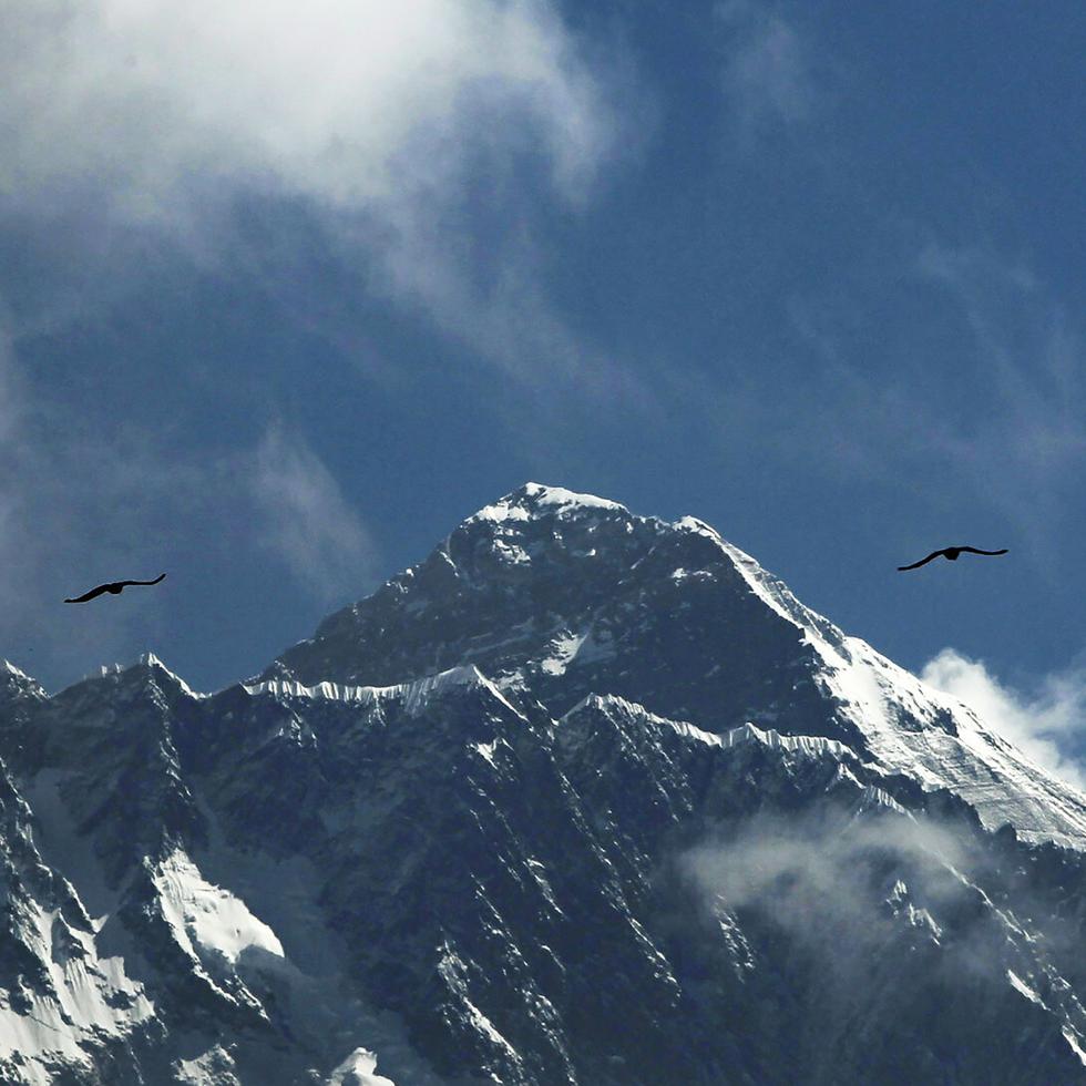 Fotografía de archivo del 27 de mayo de 2019 de aves volando con el Monte Everest al fondo visto desde Namche Bajar, distrito de Solukhumbu, Nepal.