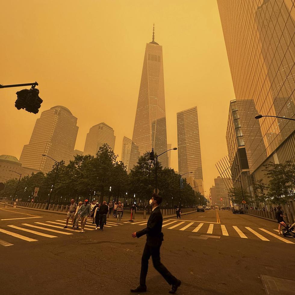 Los peatones pasan por delante del One World Trade Center, en el centro, en medio de una densa neblina de humo provocada por los incendios forestales en Canadá, el miércoles 7 de junio de 2023, en Nueva York. 