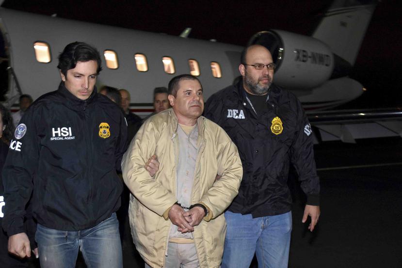 Dos agentes escoltan a Joaquín “El Chapo” Guzmán, al centro, en el aeropuerto Long Island MacArthur en Ronkonkoma, Nueva York. (AP)