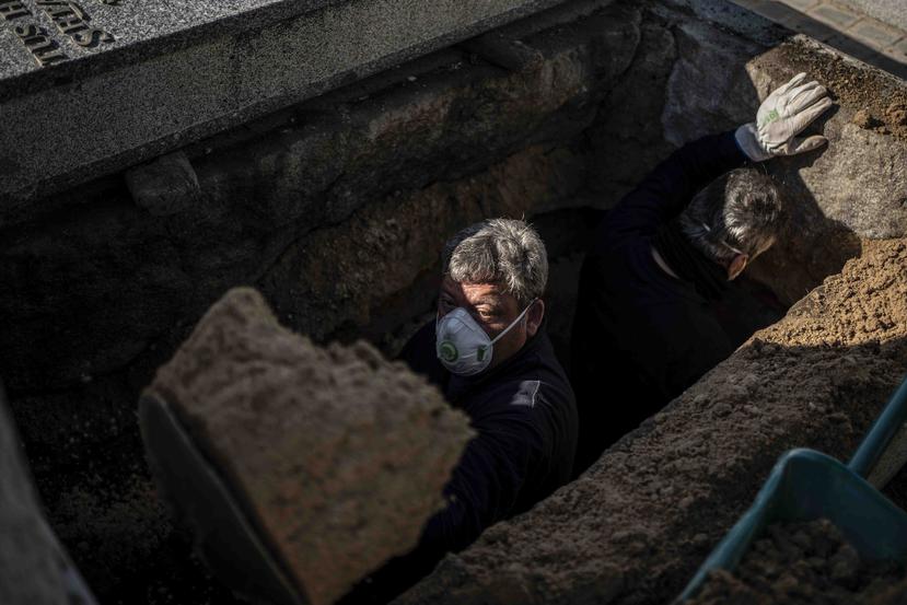 Un trabajador prepara la tumba de una persona que falleció por el coronavirus en Madrid. (AP/Olmo Calvo)