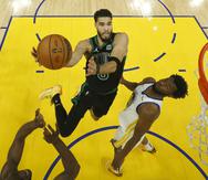 El alero de los Celtics de Boston Jayson Tatum, busca encestar Andrew Wiggins, de los Warriors de Golden State, en el quinto juego de las Finales de la NBA el lunes.