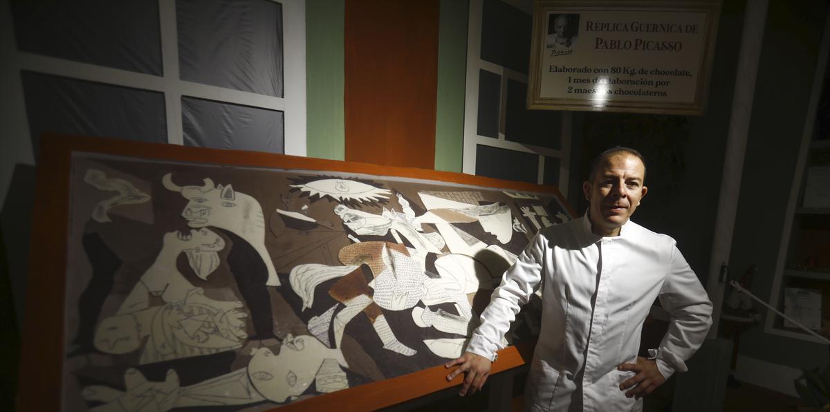 Jorge Garrido ante el cuadro del Guernica elaborado con chocolate en el obrador Galleros Artesanos de Rute (Córdoba, España).