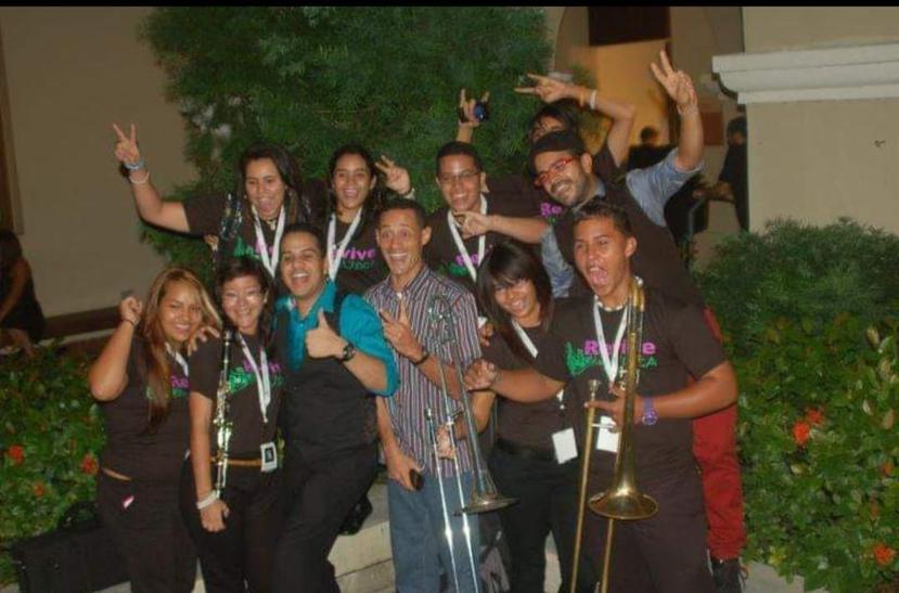 Group of young musicians from the Escuela Superior Ramón Quiñones Medina, in Yabucoa, together with the members of the group NG2 and their music teacher, Leftie O. Millán, in the center with a striped shirt.