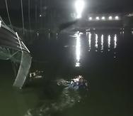 Rescatistas en botes buscan en el río Machchu junto a un puente atirantado colapsado en el distrito de Morbi, estado occidental de Gujarat, India.