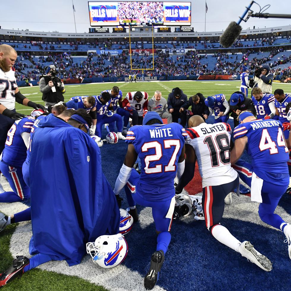 Los jugadores de los Bills de Buffalo y los Patriots de Nueva Inglaterra oran tras su partido en Orchard Park, en Nueva York.