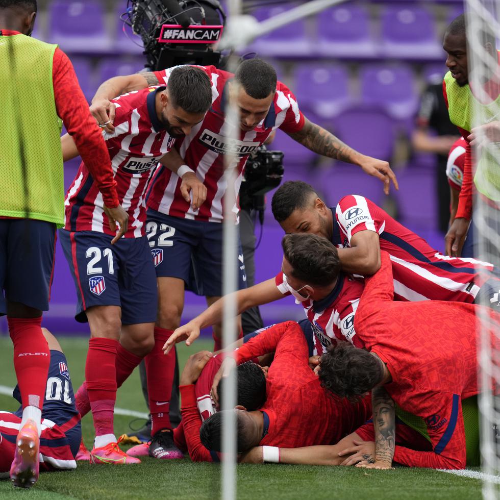 Los jugadores del Atlético de Madrid celebran con Luis Suárez luego que éste anotó el segundo gol del Atlético de Madrid en la victoria 2-1 contra Valladolid y que aseguró al equipo el campeonato del torneo nacional.