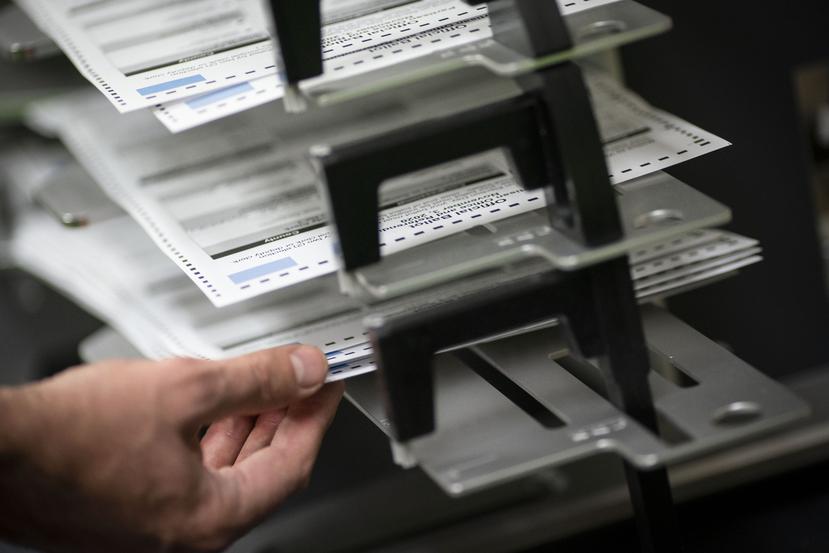 Trabajadores electorales sortean boletas de votación adelantada y por correo en el edificio municipal de Kenosha, Wisconsin.