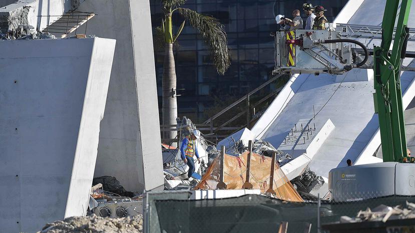 Equipos de rescate del condado Miami-Dade trabajan entre los escombros de un nuevo puente de 950 toneladas que se desplomó frente a la Universidad Internacional de Florida y dejó varios muertos, el 15 de marzo de 2018, en Miami. (AP/Michael Laughlin)