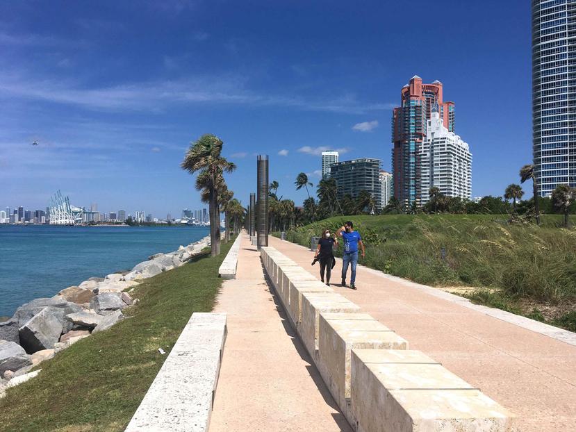 Una pareja camina por el parque South Pointe en Miami Beach. (EFE)