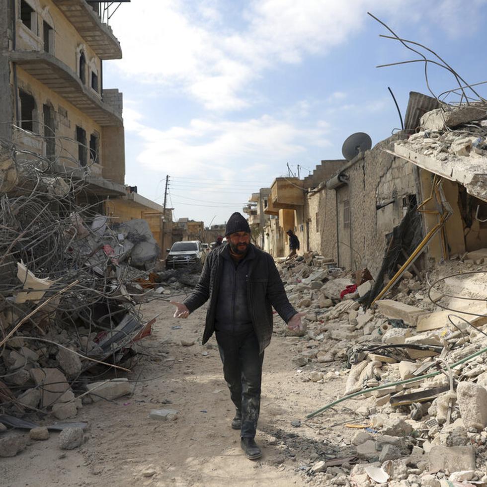 Un hombre camina entre edificios derribados por un devastador sismo, en la localidad de Jinderis, en la provincia de Alepo, Siria, el 14 de febrero de 2023. Reabrieron las escuelas en el noroeste de Siria el sábado 25 de febrero de 2023, luego de permanecer cerradas durante casi tres semanas debido al sismo que asoló esta región en poder de los rebeldes, informaron las autoridades locales. Muchos niños permanecen en estado de shock. (AP Foto/Ghaith Alsayed)
