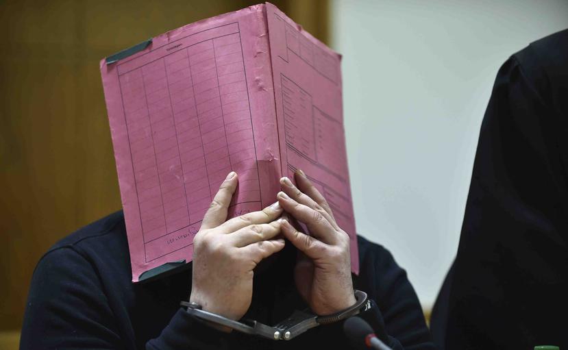 El enfermero Niels Hoegel se cubre el rostro durante su juicio en el tribunal regional de Oldenburg, en el norte de Alemania. (AP)