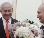 El presidente ruso Vladímir Putin, derecha, se prepara para saludar a la esposa del primer ministro israelí Benjamin Netanyahu, Sara, quien no aparece en la foto, antes de conversar con Netanyahu en el Kremlin, el 30 de enero de 2020, en Moscú, Rusia.