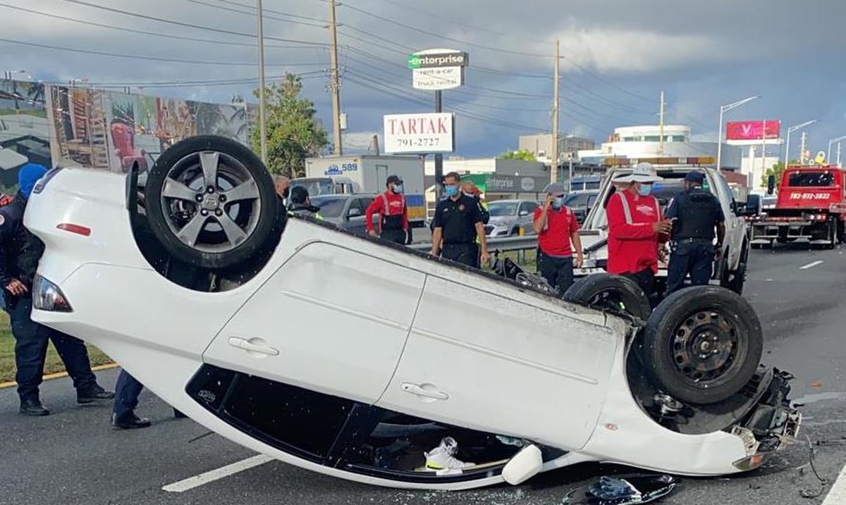 Remove an overturned car in front of Luis Muñoz Marín Airport