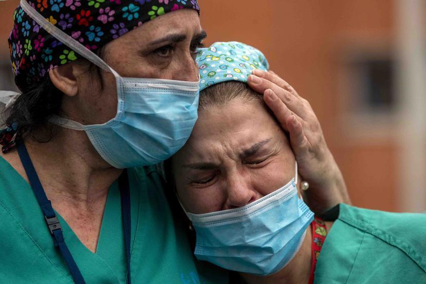 Dos trabajadoras de la salud lloran la muerte de un enfermero en el  Hospital Severo Ochoa en Leganés, España. (AP)