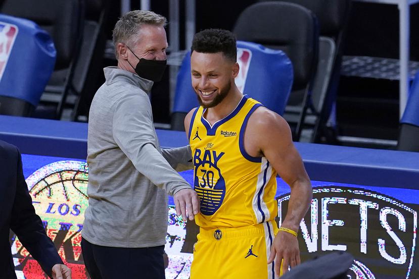 El entrenador de los Warriors de Golden State, Steve Kerr, a la izquierda, celebra con Stephen Curry después de que los Warriors derrotaran a los Bucks de Milwaukee.