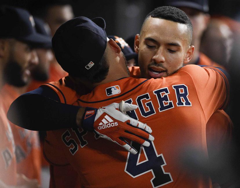 Carlos Correa se abraza con su compañero George Springer en el dugout luego de pegar un cuadrangular. (AP)