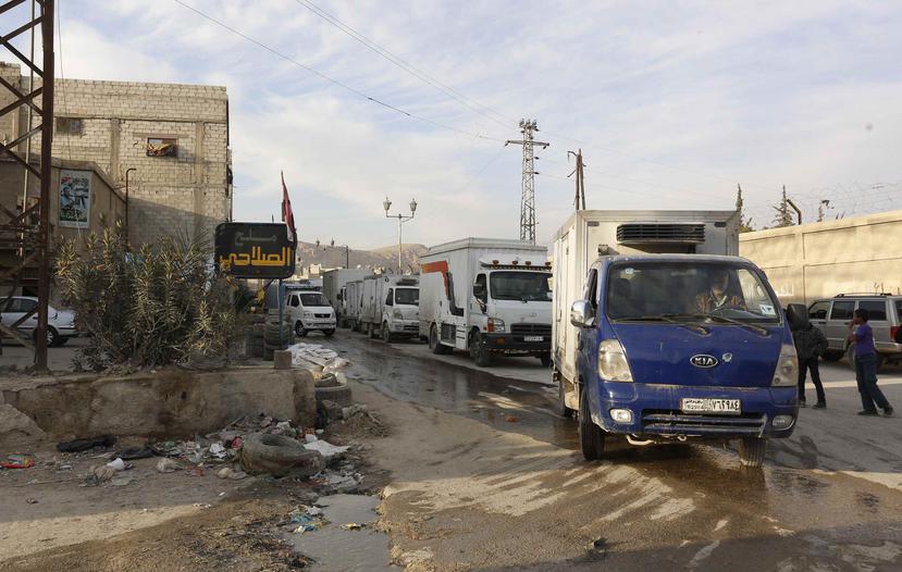 Camiones que transportan material de ayuda entran en la ciudad de Douma en el campo de Damasco, en Siria. (EFE)