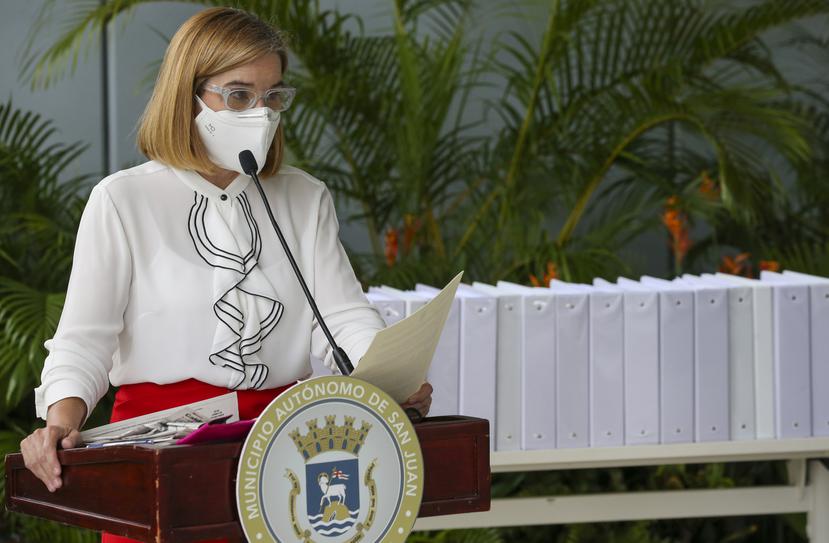 La alcaldesa de San Juan, Carmen Yulín Cruz, quien al fondo tiene las carpetas que contienen la información relacionada con el proceso de transición del municipio.