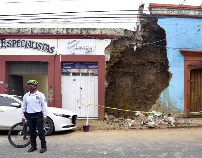 Un policía permanece de pie el martes 23 de junio de 2020 frente a una construcción que sufrió daños tras un terremoto en Oaxaca, México.