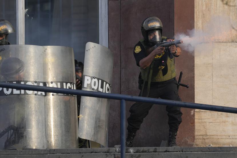 Un policía dispara gases lacrimógenos para dispersar a simpatizantes del destituido presidente Pedro Castillo.