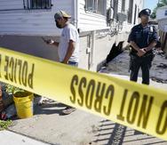 Un oficial de policía vigila la escena donde se inspecciona los daños a la casa donde murieron personas después de que el sótano de su apartamento se inundó en el vecindario de Jamaica en el distrito de Queens de Nueva York.