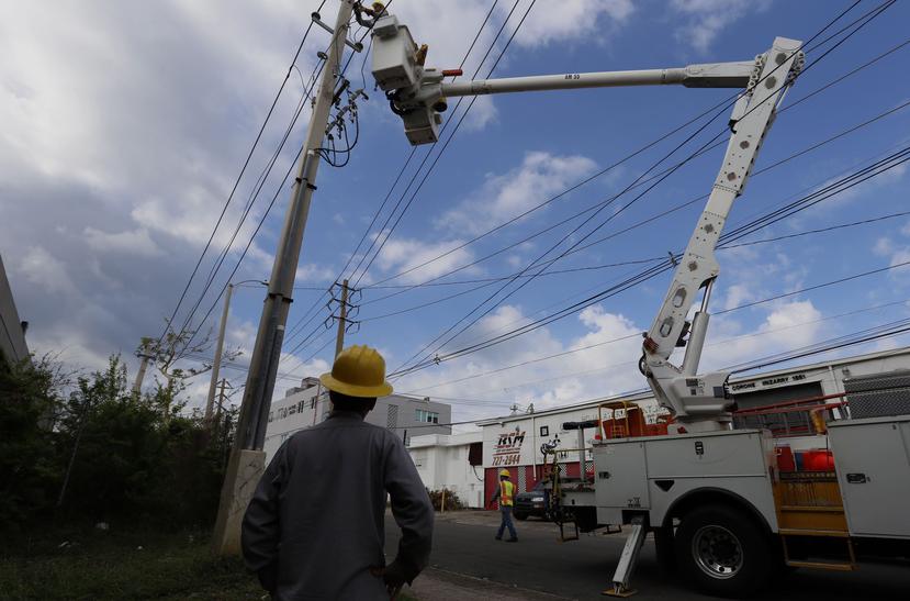 Dos empleados de la AEE reparan la electricidad en Santurce. (EFE)