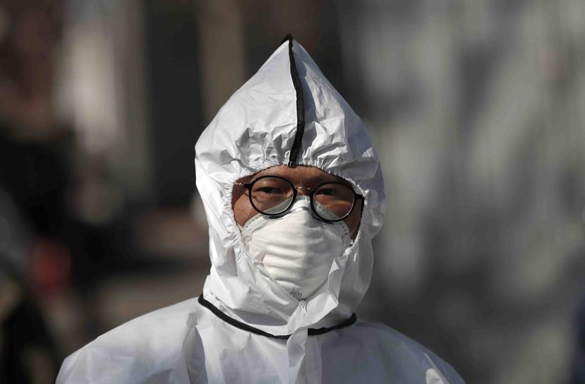 Un trabajador con equipo de protección se prepara para rocíar desinfectante como precaución contra el nuevo coronavirus en Seúl, Corea del Sur. (AP)