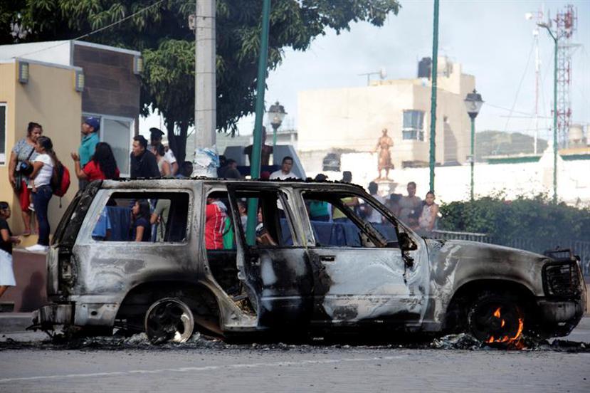 La multitud incendió también la guagua en la que llegaron los hombres a la comunidad de Acatlán de Osorio, en Puebla. (AP)
