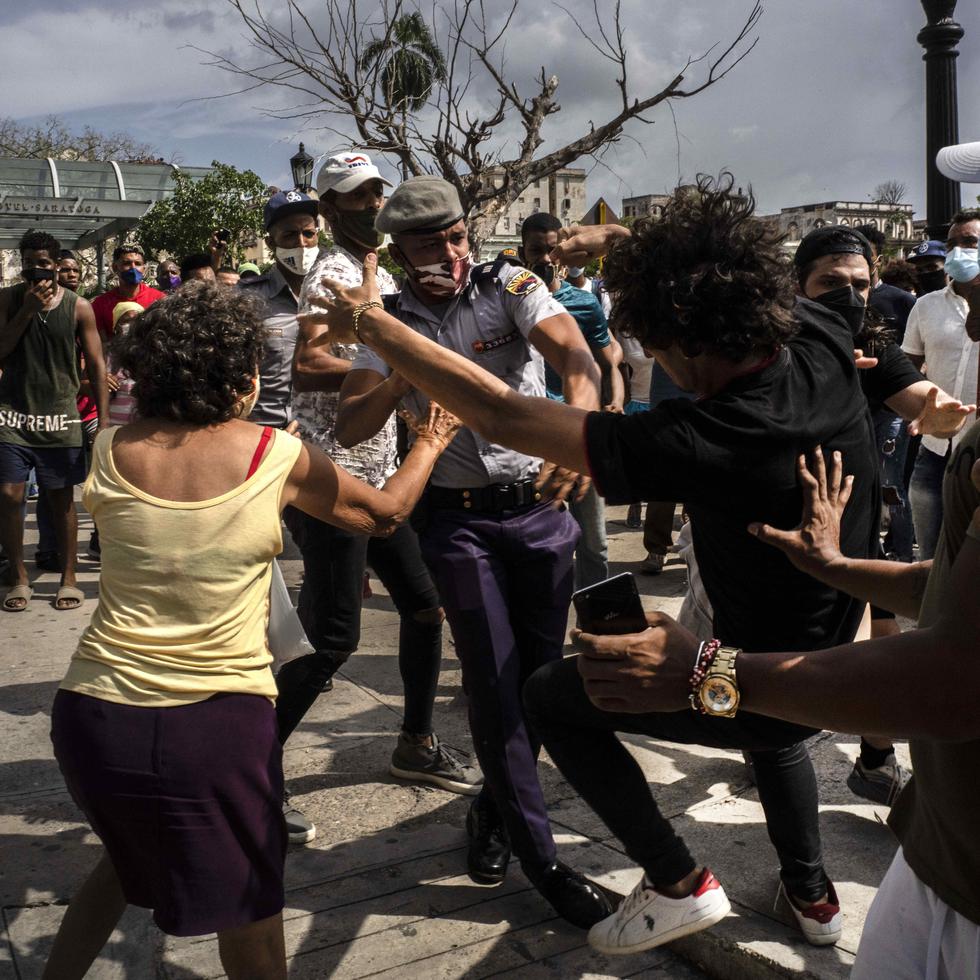 La policía pelea y detiene a un manifestante antigubernamental durante una protesta en La Habana, Cuba.